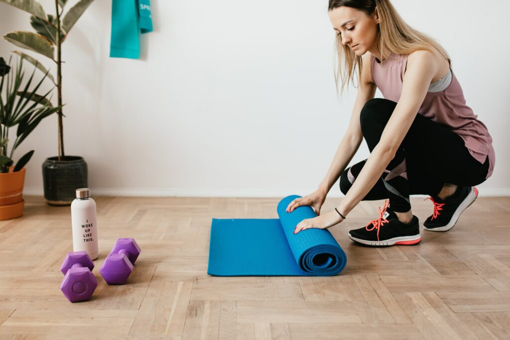 Young female employee rolling gym matt.