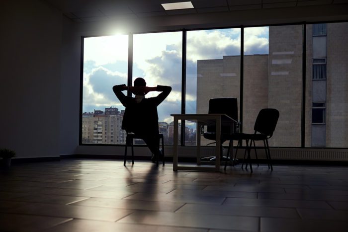 a person sitting in dark office building looking at the clouds