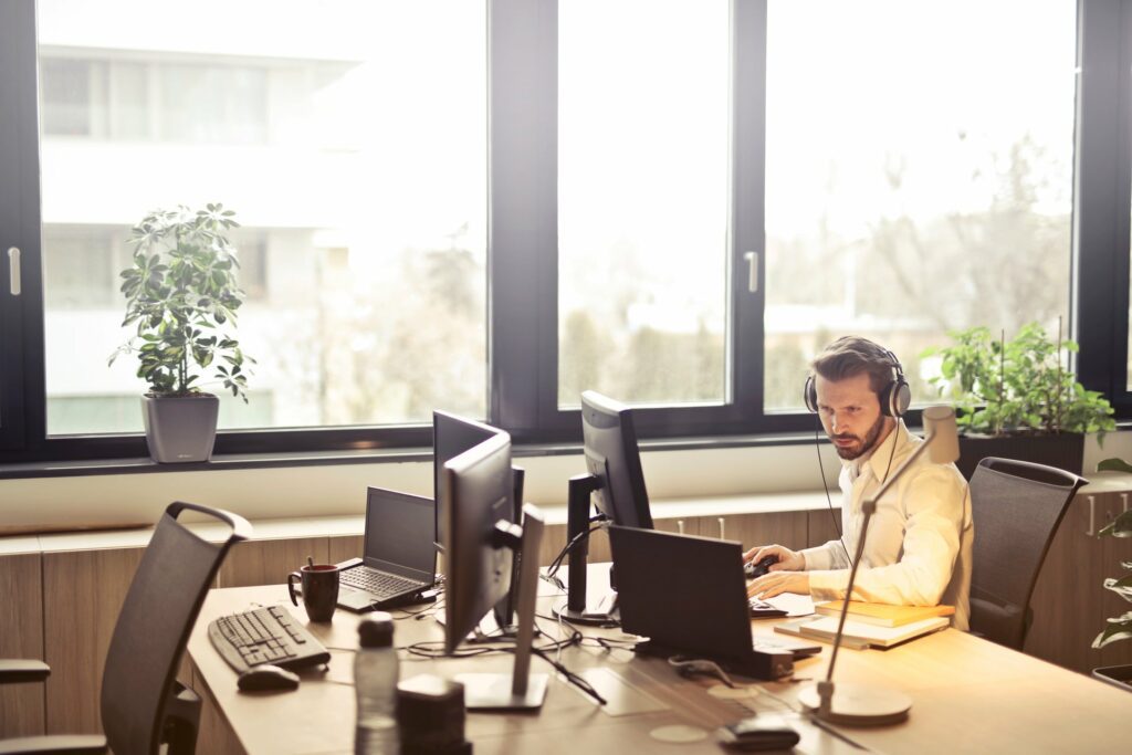 man sitting in the office wearing headphone in modern office providing IT business solutions