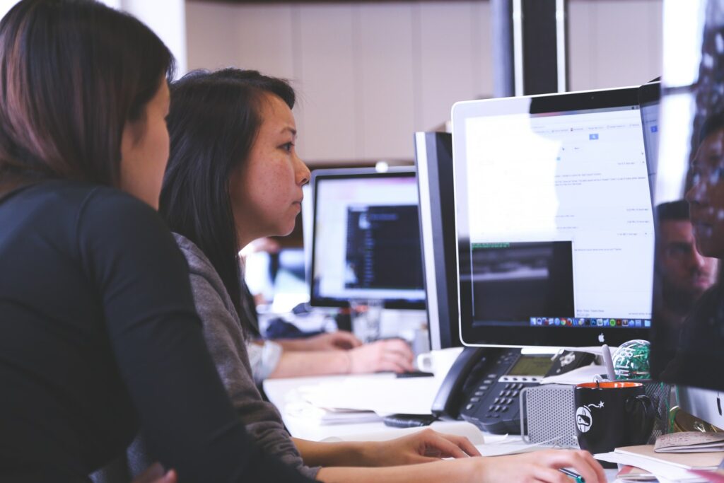 two women looking at the computer for IT business solutions