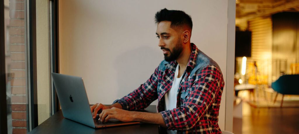 Employee working with laptop on measuring candidate experience.