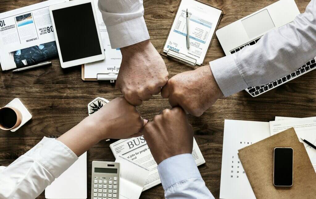 Recruiting team members joining hands with folded wrist.