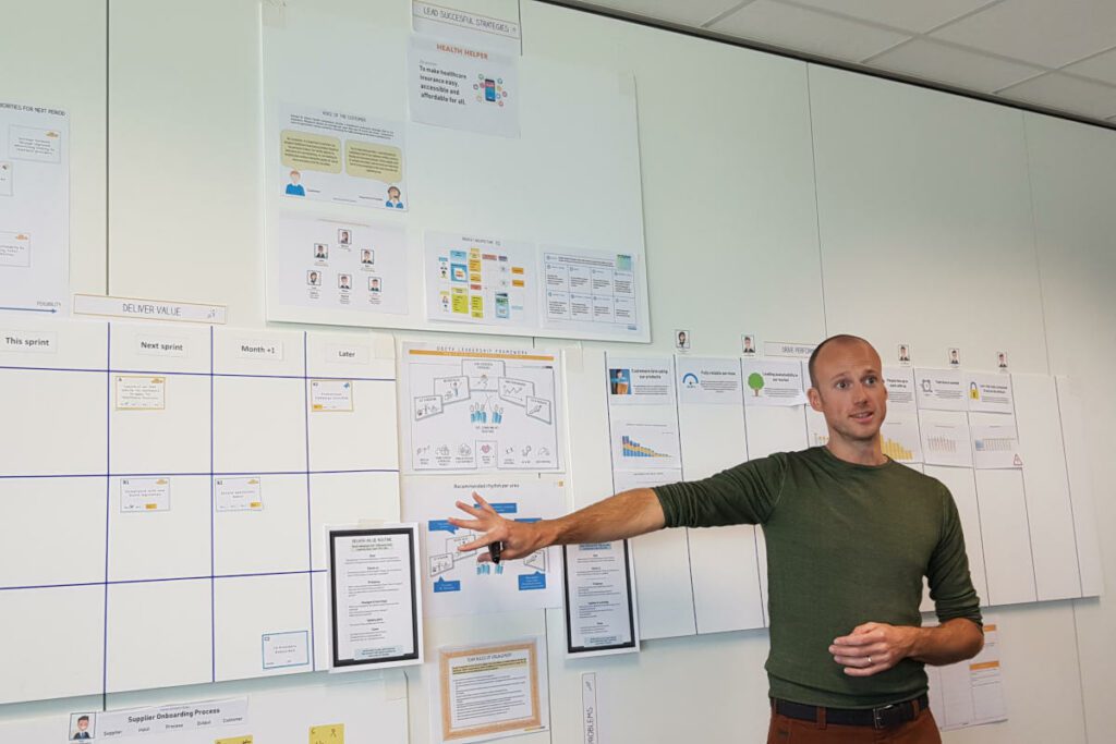 UX engineer explains design patterns to team on white board.