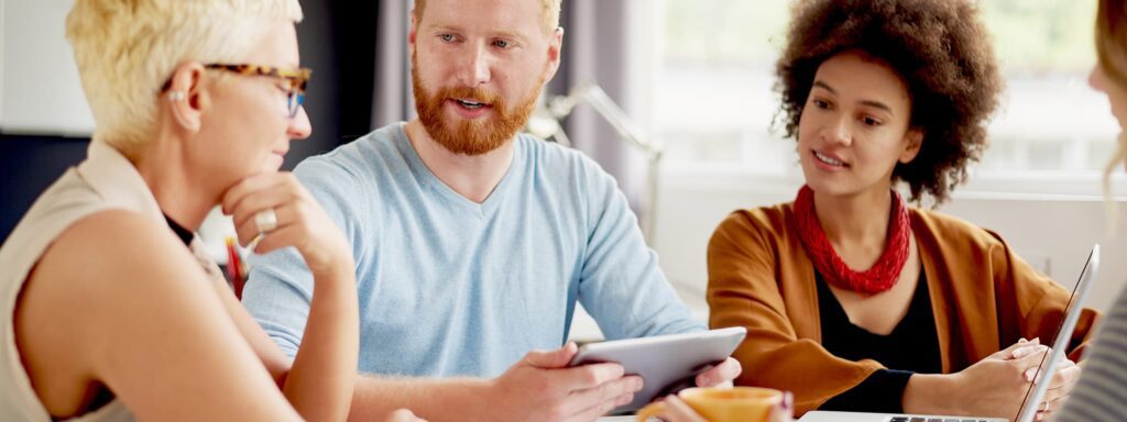 IT professionals discussing on Azure SQL database sharing tablet and laptop screen