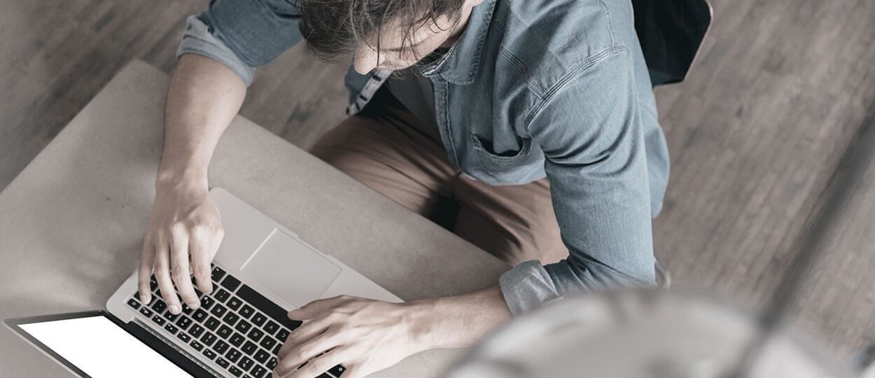 Top view of IT engineer working with laptop on desk.