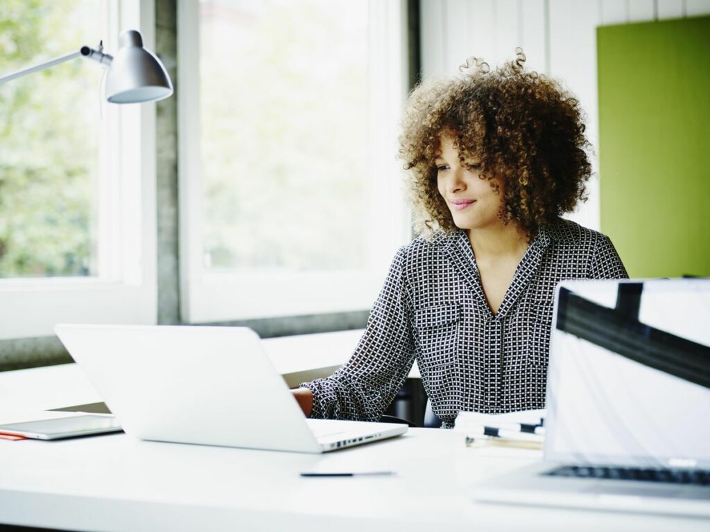 Female IT woman working on AI implementation platform with laptop from office desk