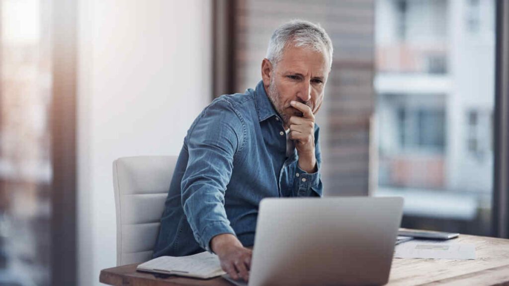 Senior Businessman working Complexity and ROI assessment with laptop.