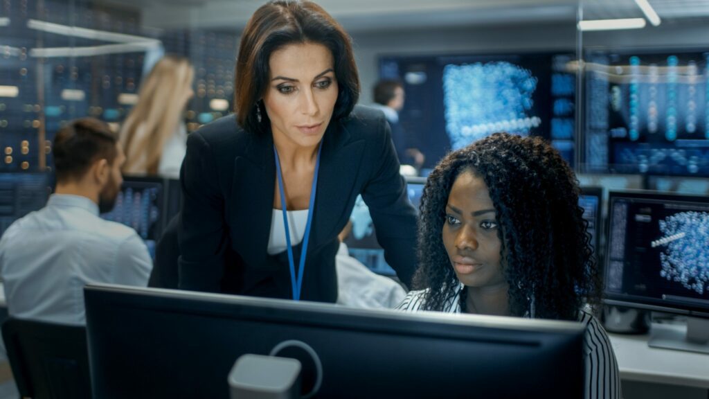 Female Security assessment manager helping coworker on understanding different data breaches organisations get affected with
