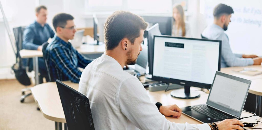 men and woman looking at their computer screen analyzing security risks