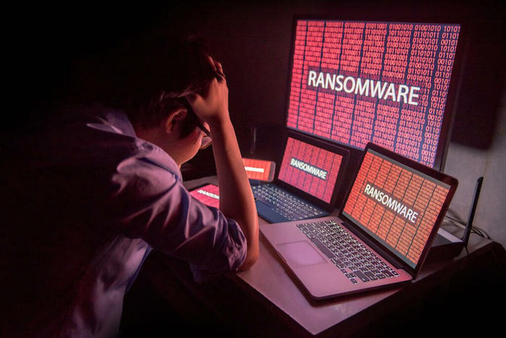 frustrated employee suffering with ransomware hack on laptops, desktops, tablets and mobile