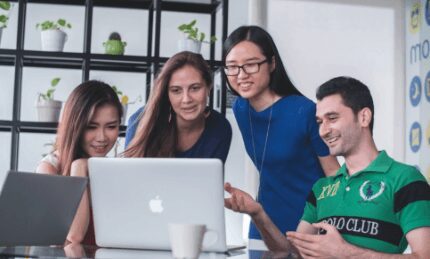 group of employees sharing laptop screen