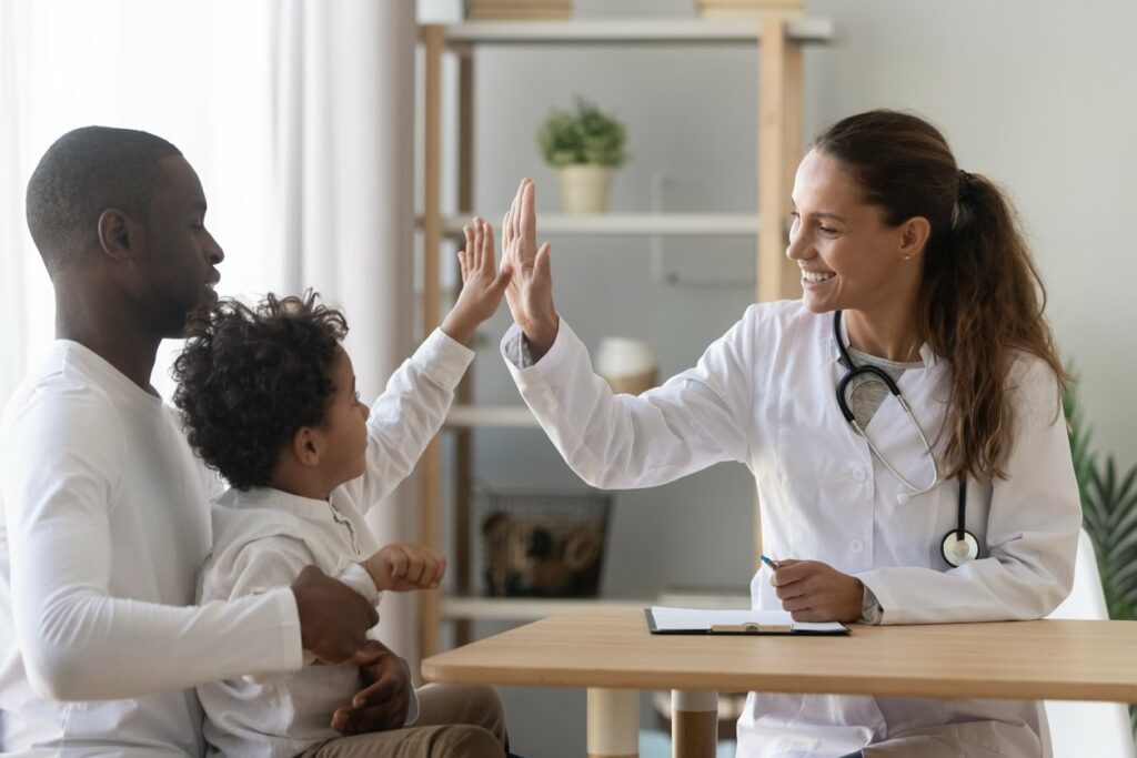 doctor giving hifigh to young child 