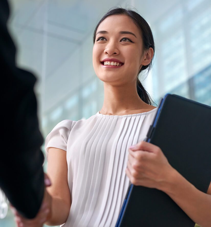 Women shaking hand with colleague smiling