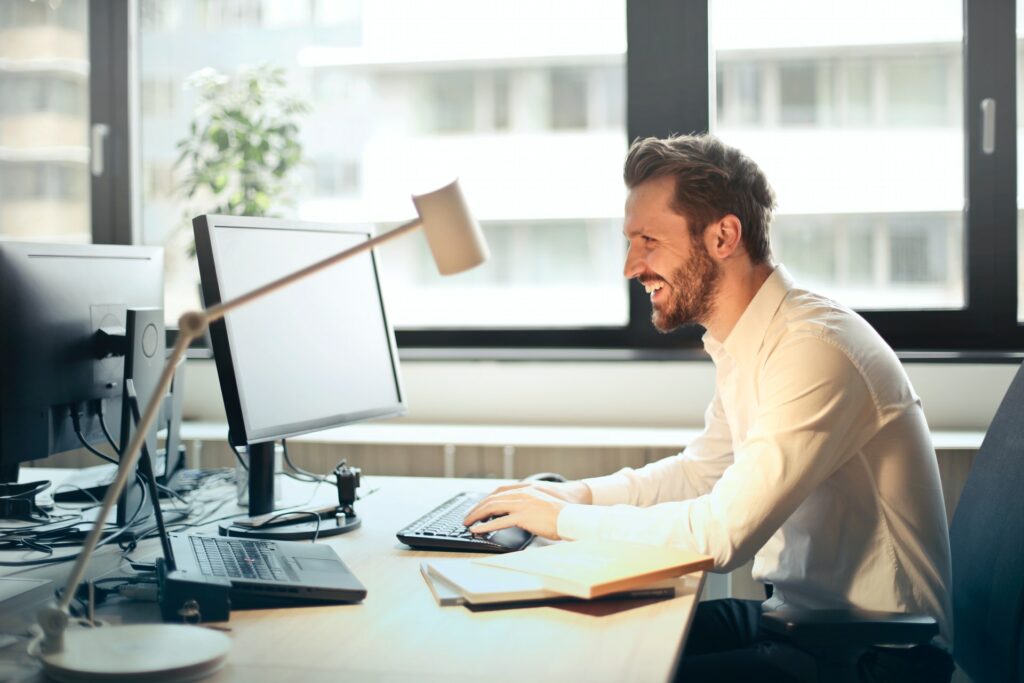 a person sitting on the desk and working on laptop and leveraging Ai decision capabilities