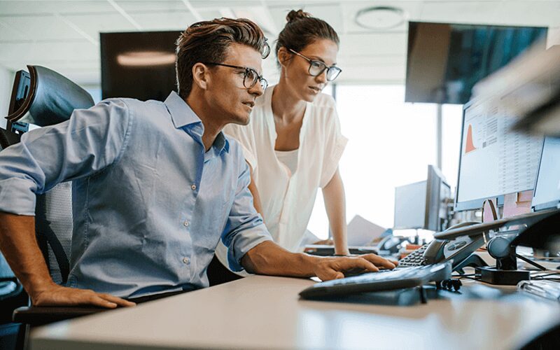 a man and a woman looking at computer screen and reviewing endpoint security