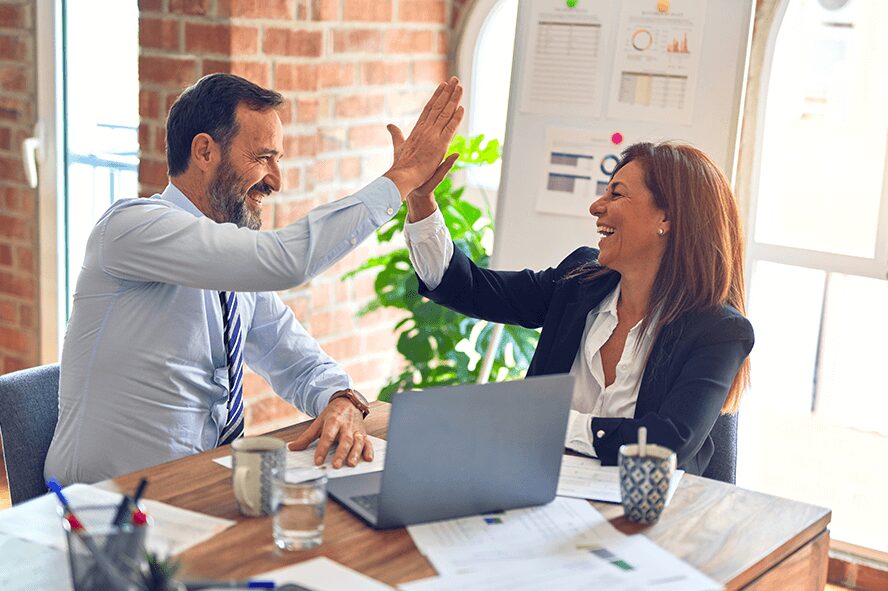 Two employees giving high five to each other for implementing automation in their process