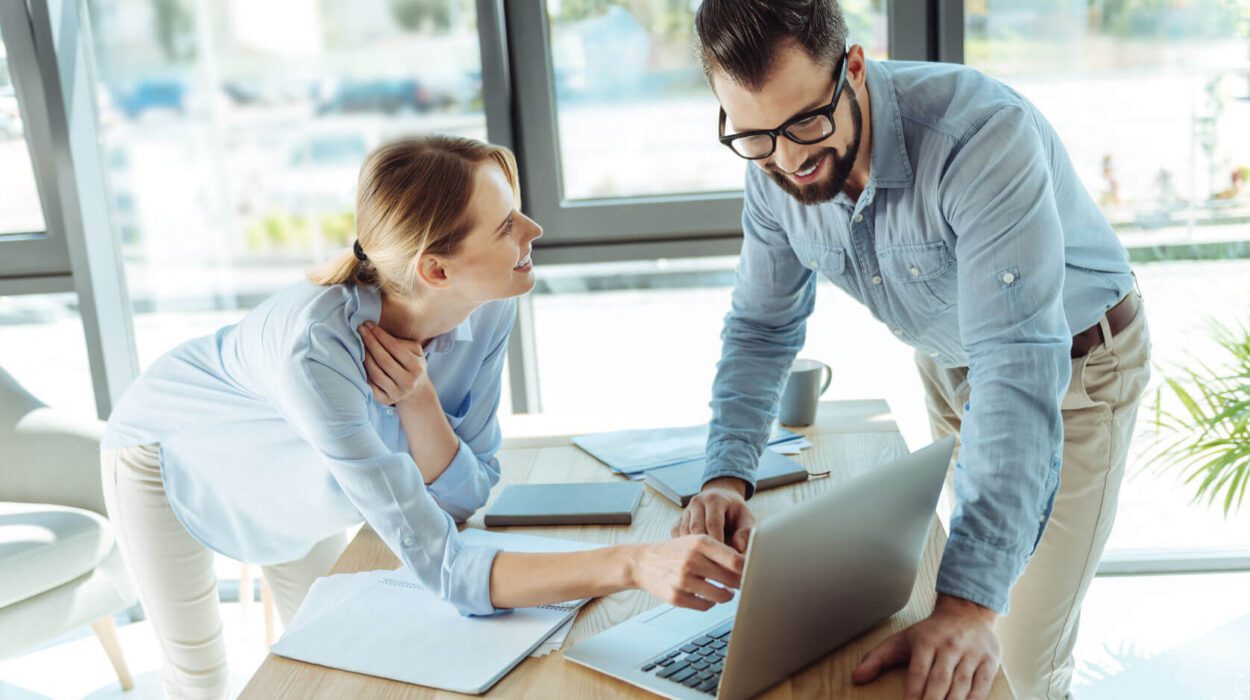 pleasant colleagues watching a video tutorial on laptop