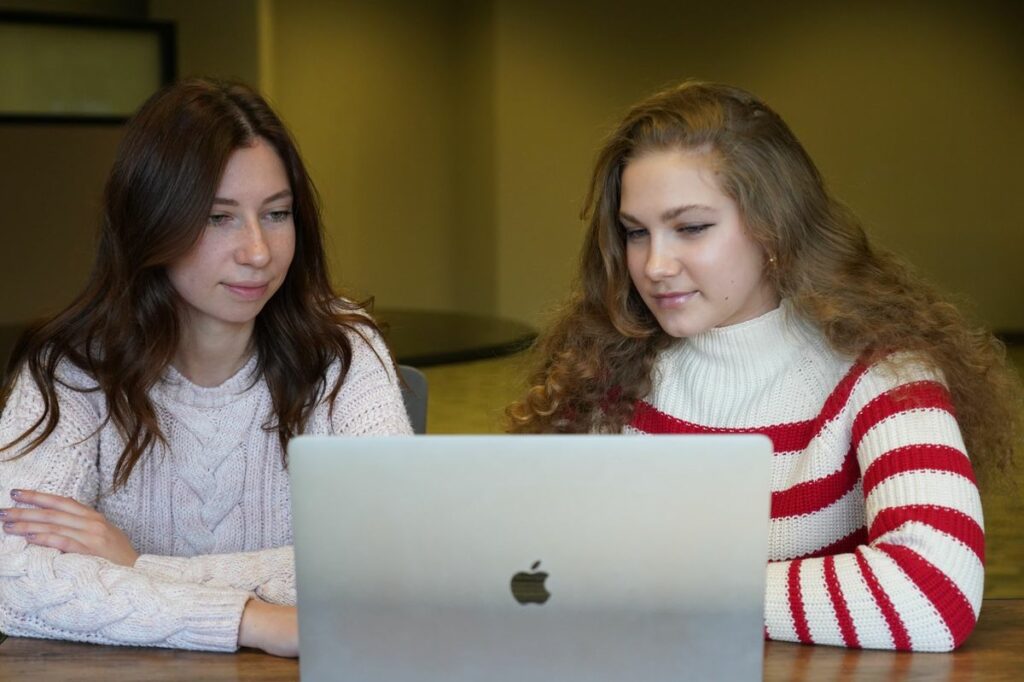 Two women reading on laptop about TPS for Ukrainian nationals