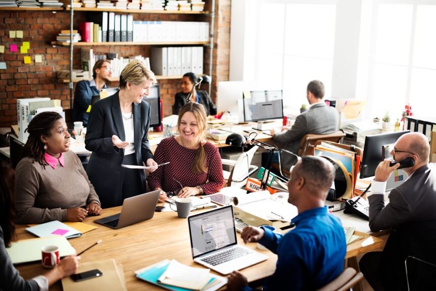 men and women sitting in the office and talking about Microsoft Inspire 2022