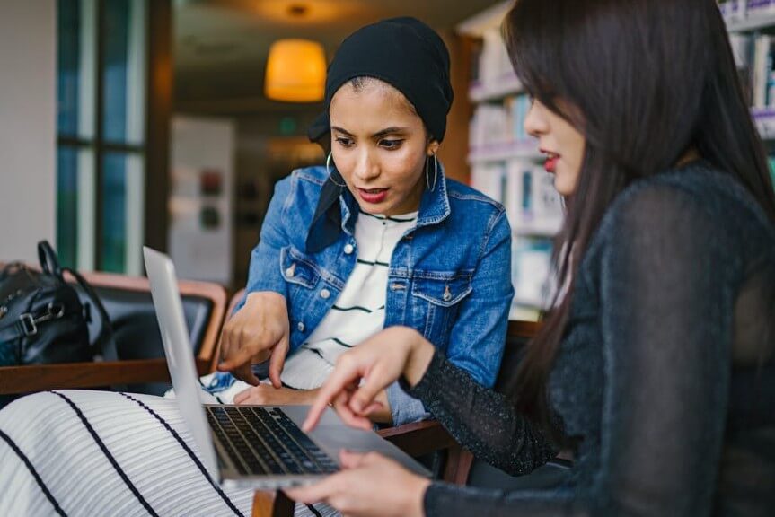 two women looking for information on H-1b1 visa on laptop